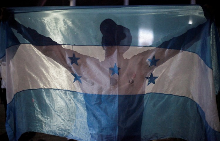 A demonstrator holds a Honduran flag during a protest against Honduras President Xiomara Castro's government and in support of the extradition treaty with the U.S., in Tegucigalpa, Honduras September 6, 2024. REUTERS/Fredy Rodriguez